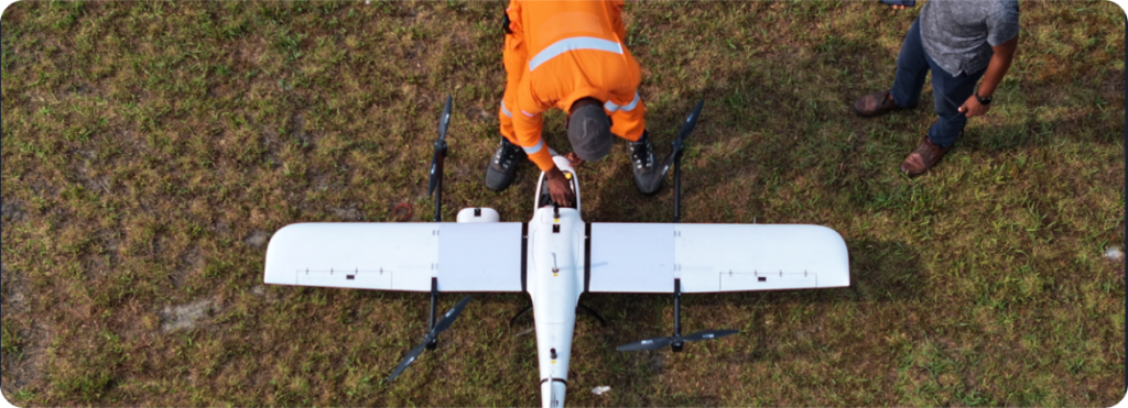 People operating a drone in a field