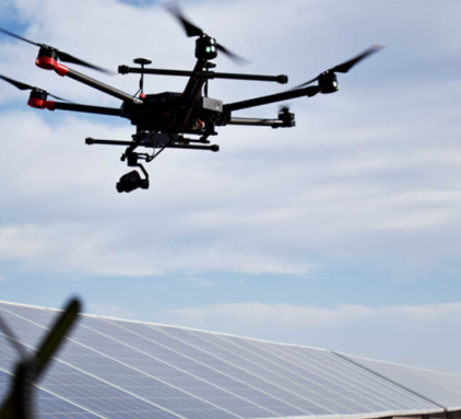 A drone flying over a row of solar panels