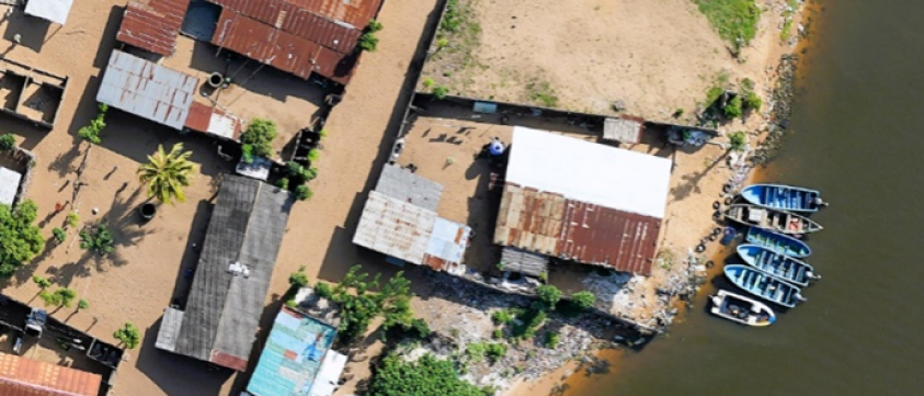 An aerial view of a small town with boats docked on the shore of a river.