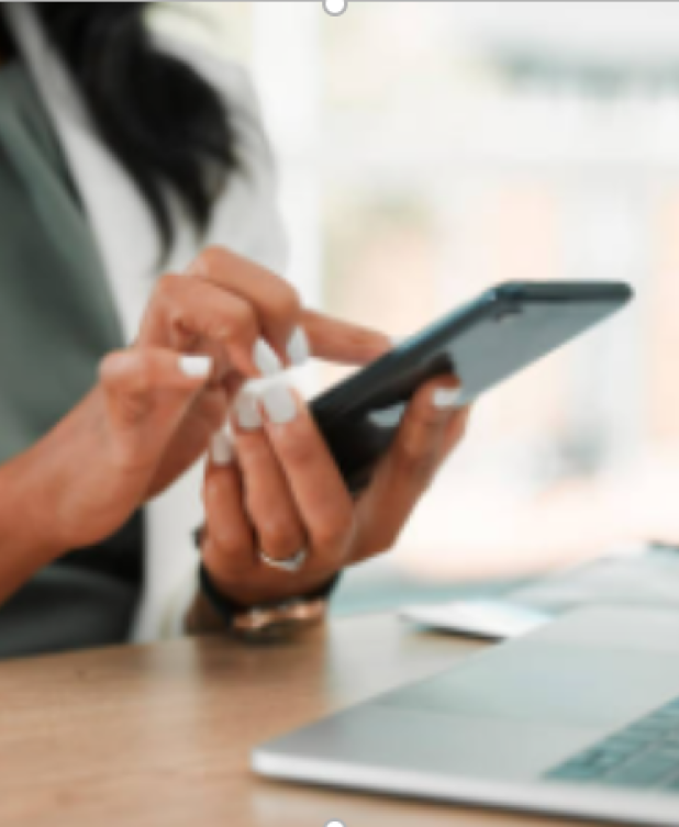 A person using a cell phone at a desk.